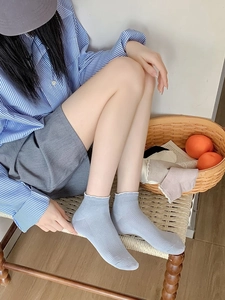 Gros plan de chaussettes en fibre de bambou bleu clair avec rayures et bords dentelle