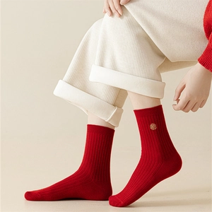 Detailed shot of red cotton festive socks featuring golden embroidery and ribbed texture