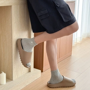 Detail of earthy-tone EVA platform slides paired with gray knitted crew socks