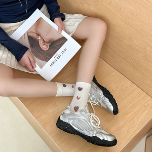 Silver metallic platform sneakers with breathable mesh and heart pattern socks on stairs
