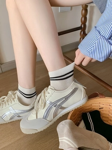 Détail de chaussettes en fibre de bambou beige à deux rayures avec baskets décontractées