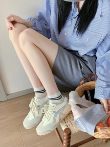 Gros plan de baskets rétro crème à rayures grises et chaussettes en fibre de bambou