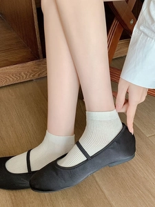 Close-up of white vertical striped bamboo fiber crew socks worn with Mary Jane shoes
