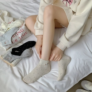 Close-up of cotton socks with embroidered animal icons and classic polka dot patterns