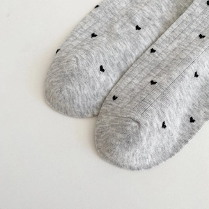 Close-up of grey breathable mesh socks with black heart pattern and smooth toe seams