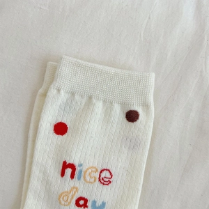 Detail of white cotton sports socks featuring nice day embroidery and mesh texture