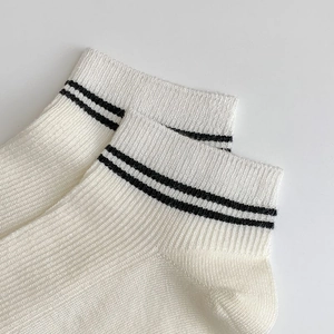 Zoom sur les bords-côtes de chaussettes en bambou beige avec deux bandes noires