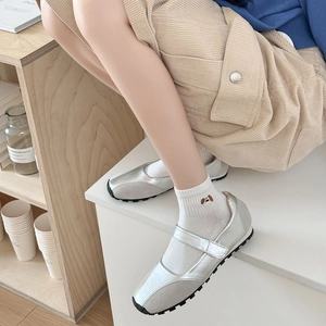 Detail of silver Mary Jane sneakers with velcro straps and cute dog embroidery socks