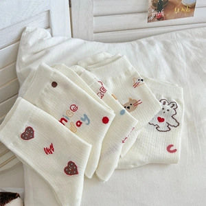 Detail of soft cream cotton crew socks featuring cute cartoon patterns and nice day letters