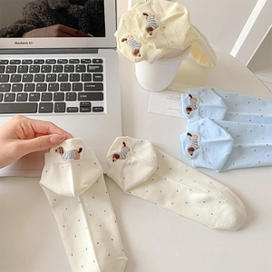 Detail of embroidered dachshund puppy and black polka dots on cotton crew socks