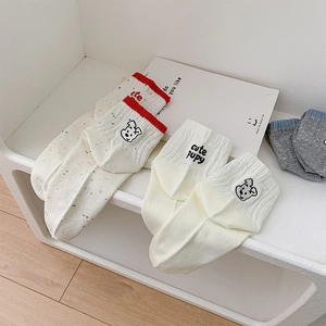 Close-up of cute puppy embroidery and colorful polka dots on premium cotton socks