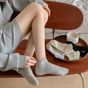 Close-up of gray cotton low-cut socks with polka dots and a cute white dog embroidery