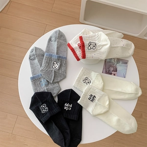 Detailed embroidery of a cute puppy and text on various colors of cotton crew socks