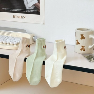 Detail of cute puppy embroidery on breathable cotton crew socks in pastel colors