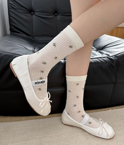 Détail de la broderie florale sur chaussettes transparentes et ballerines Mary Jane