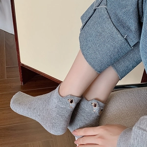 Close-up of grey cotton low-cut socks featuring a cute embroidered dachshund dog detail