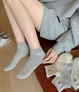 Detail of cotton ankle socks with cute dachshund embroidery and blue polka dot patterns