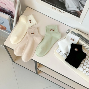 Close-up of cute cartoon puppy embroidery and ribbed cuffs on colorful mesh cotton socks