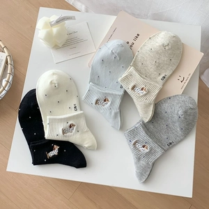 Detailed close-up of cute cotton socks featuring dachshund embroidery and polka dot patterns