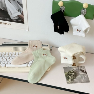 Close-up of cute puppy embroidery on cotton crew socks in five pastel colors