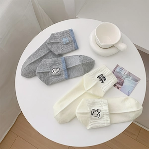 Detail of cute puppy embroidery on cotton socks with ribbed cuffs in grey and cream
