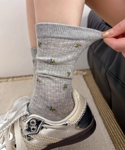 Gros plan de chaussettes en résille élastique avec broderie florale et maille côtelée