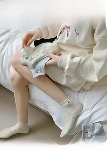 Vue détaillée de chaussettes en coton avec broderie chien et pois sur un modèle