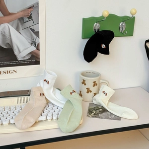 Detail showing cute puppy embroidery on colorful mesh cotton socks in pastel tones