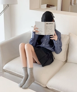 Chic Korean style outfit featuring grey ribbed cotton socks with a pleated black mini skirt