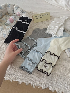 Detail of ruffled cuff and delicate bow embroidery on ribbed cotton crew socks for women