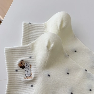 Detail of cream cotton socks with cute dog embroidery and dark grey polka dots pattern