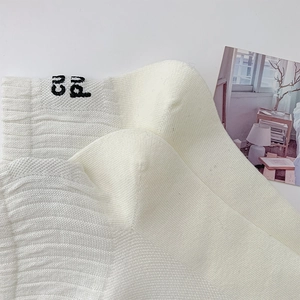 Detail of off-white ribbed cotton socks featuring black CU letter embroidery detail