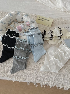 Detail of five-color ribbed mid-calf socks with lettuce edges and bow embroidery