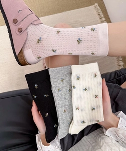 Gros plan de chaussettes mi-mollet à fleurs vintage, maille respirante et bord-côte