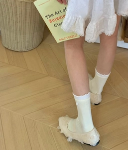 Détail de chaussettes à volants blancs avec chaussures fleurs 3D et robe en dentelle