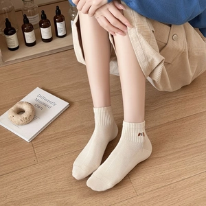 Detail of cream low-cut ankle socks with cute puppy embroidery and breathable mesh texture