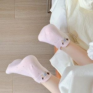Close-up of pink cotton socks with black polka dots and cute animal embroidery