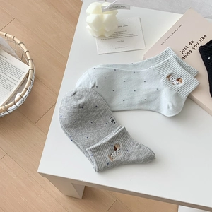 Detailed embroidery of a small dog and blue polka dots on soft breathable cotton socks