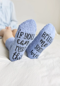 Close-up of light blue coral fleece socks with funny non-slip letter print on the soles
