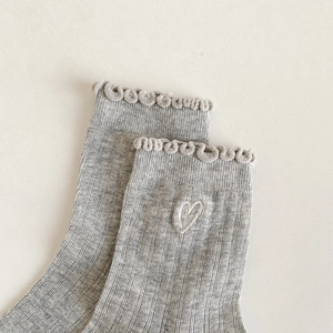 Close-up of grey cotton socks featuring lettuce edge trim and embroidered white hearts