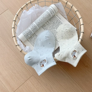 Close-up of pastel blue and grey cotton socks with cute dachshund puppy embroidery