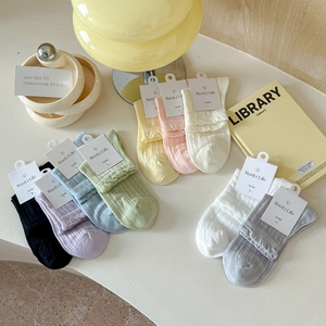 Détail de chaussettes en coton multicolores avec bords à volants et texture à côtes fines
