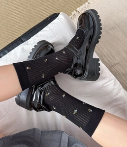 Chaussettes noires à fleurs en maille côtelée avec des chaussures Mary Jane à plateforme