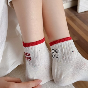 Detail of white cotton socks with cute puppy embroidery and red ribbed cuffs