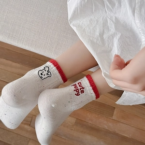 Detail of white cotton socks with cute puppy embroidery and red ribbed cuffs for women