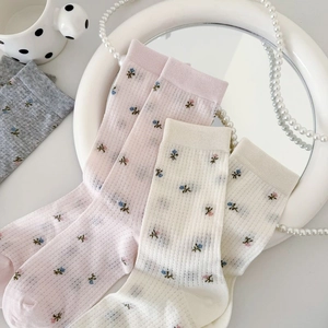 Détails de chaussettes en maille respirante avec motifs floraux vintage et bords côtelés