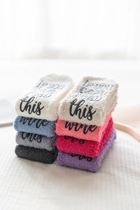 Macro shot of fluffy coral fleece socks with If You Can Read This lettering on sole