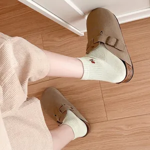 Women's brown suede mule clogs with adjustable buckle and cork sole in casual style
