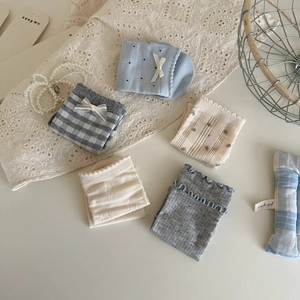 Detail of five-pair set of light blue and grey bow cotton socks in a decorative basket