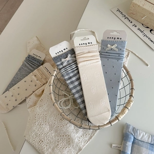 Detail of light blue and grey bow socks for women in a vintage style decorative basket
